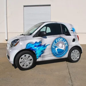 A small coupe car fully wrapped with custom vinyl graphics